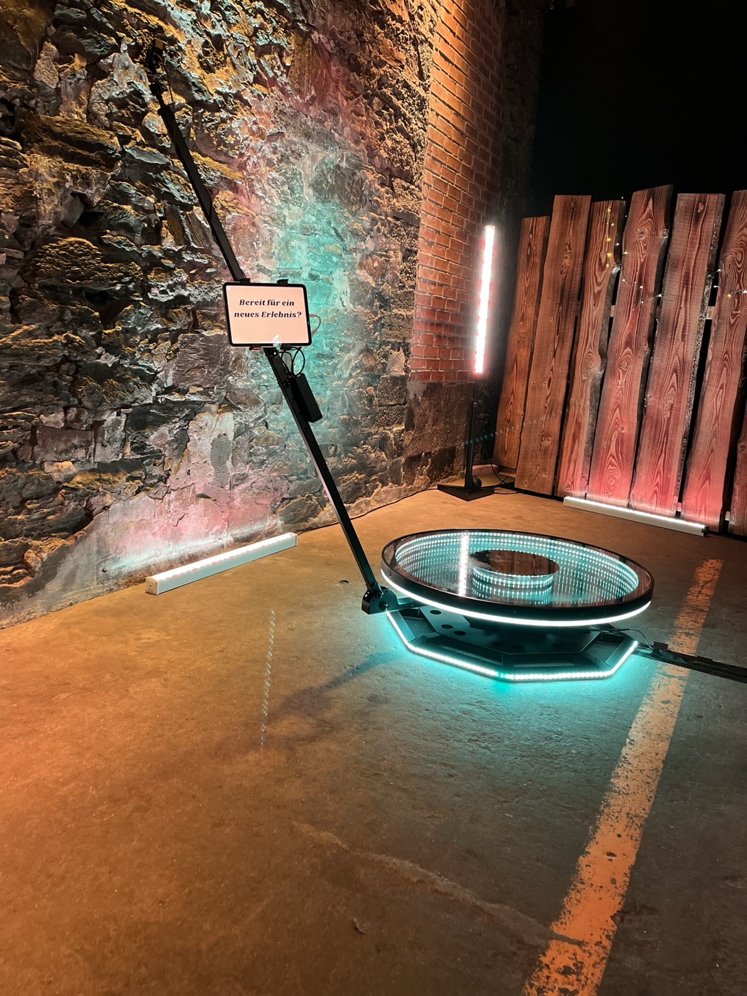 360° Video Booth mit leuchtender Plattform vor einer Natursteinwand