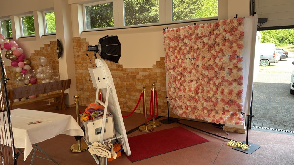 Spiegel-Fotobox vor einer Blumenwand